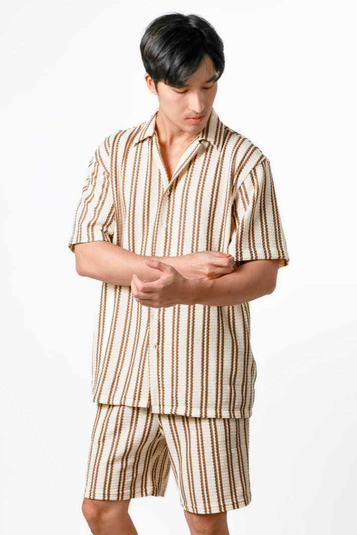 Man wearing a striped shirt and shorts set on a white background